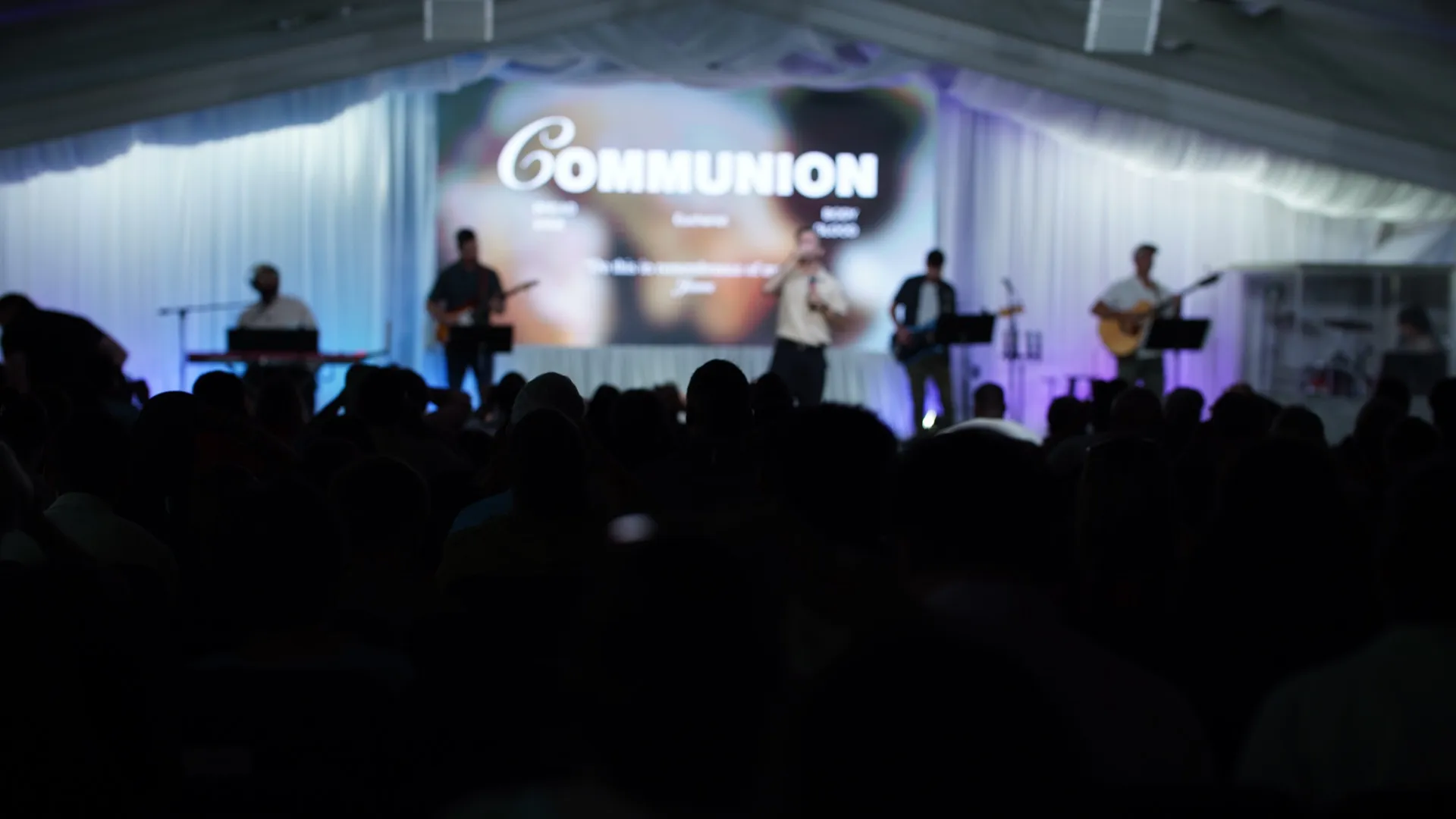 Communion at a Garden Co. gathering — the band leading worship under the tent