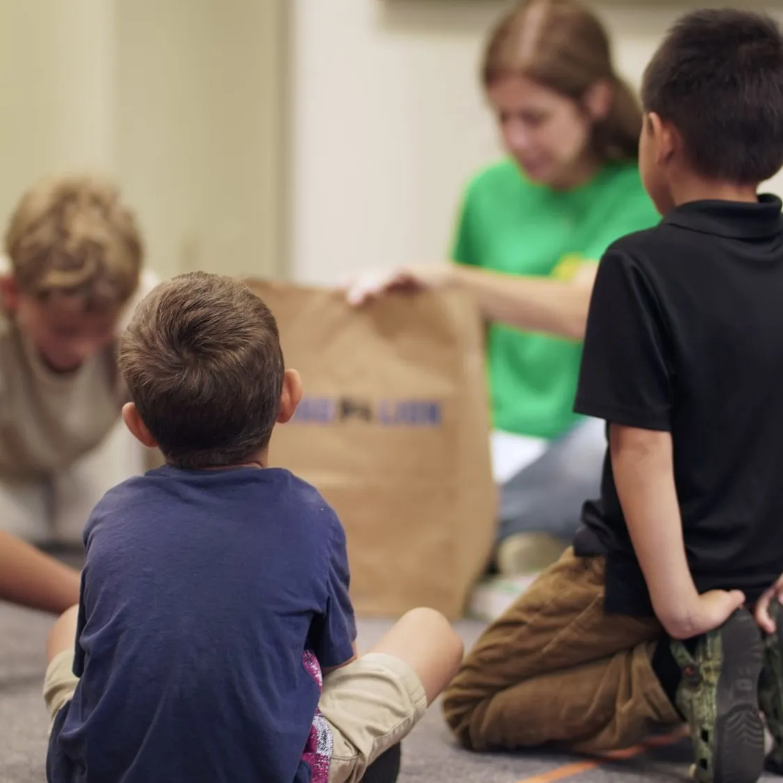 Kids gathered on the floor with a teacher in the Garden Co. kids room