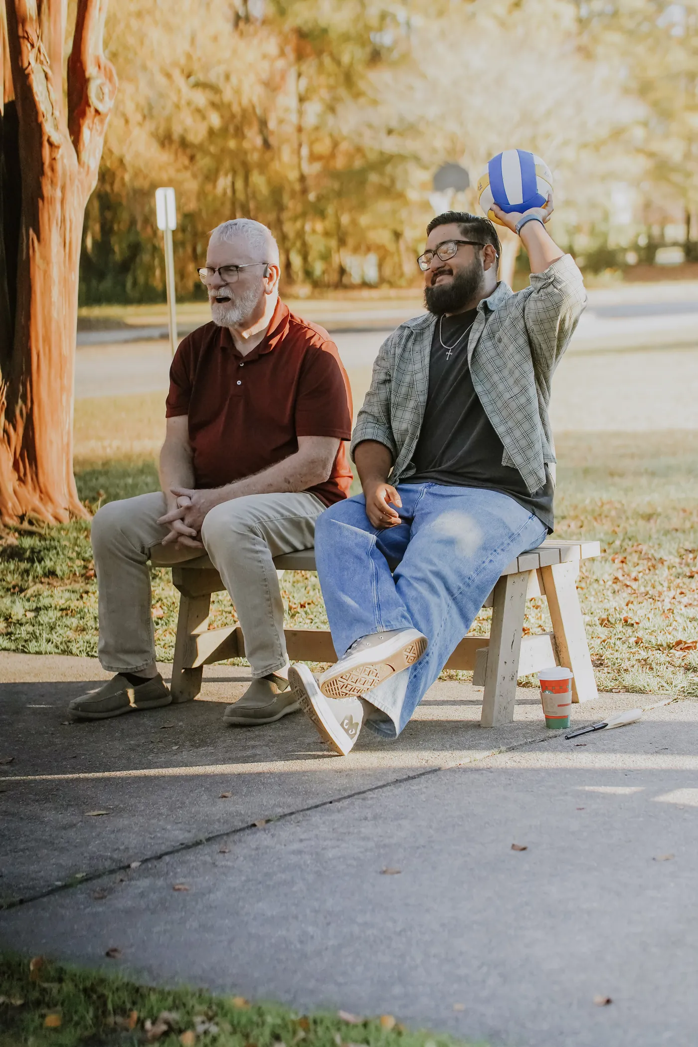Two men laughing on a bench outdoors
