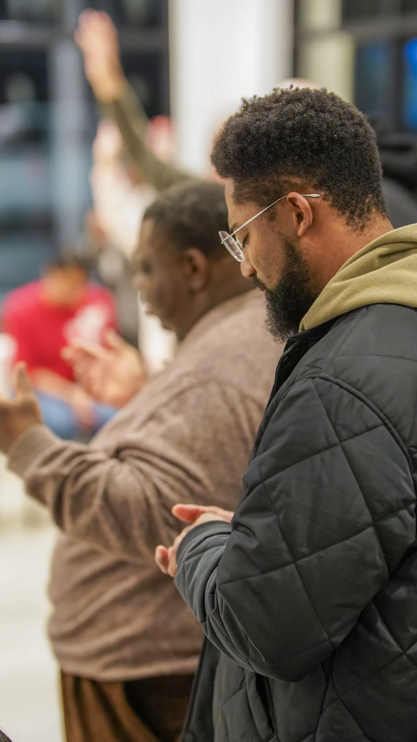 Two men praying together, hands clasped