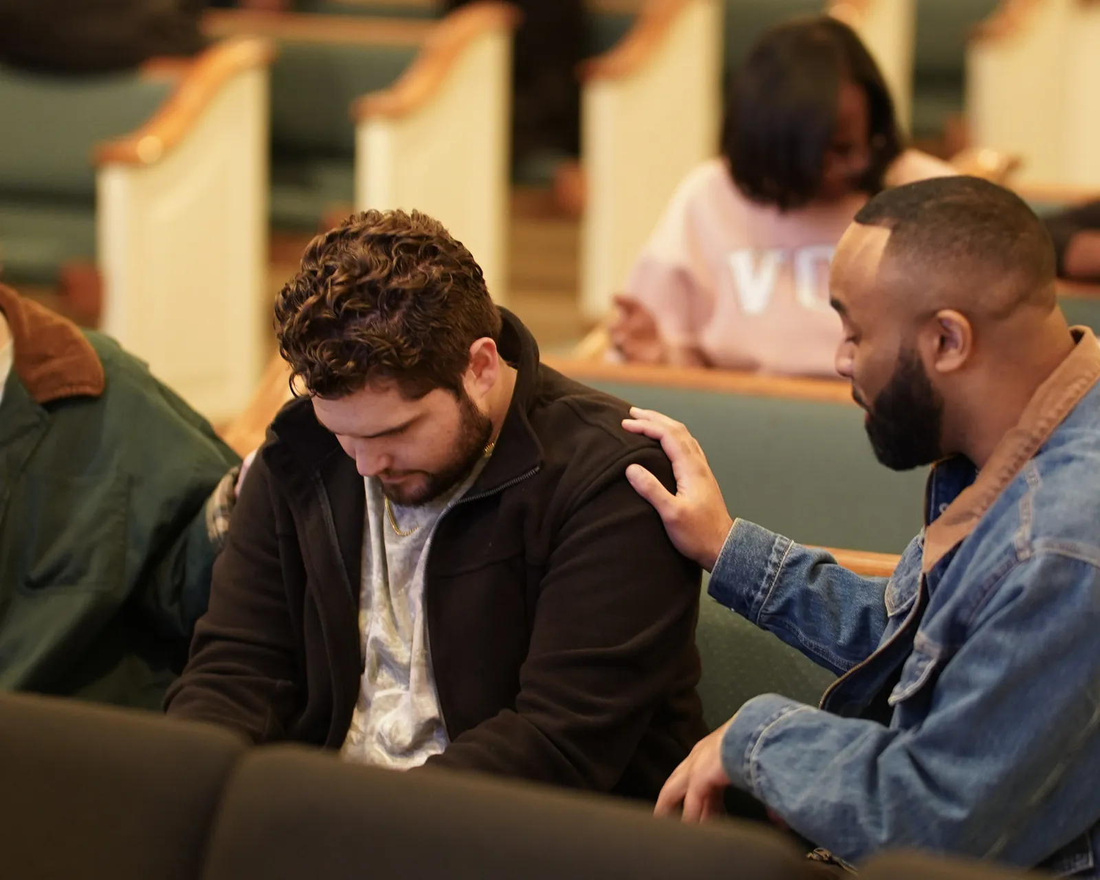 A hand on a shoulder in the pews