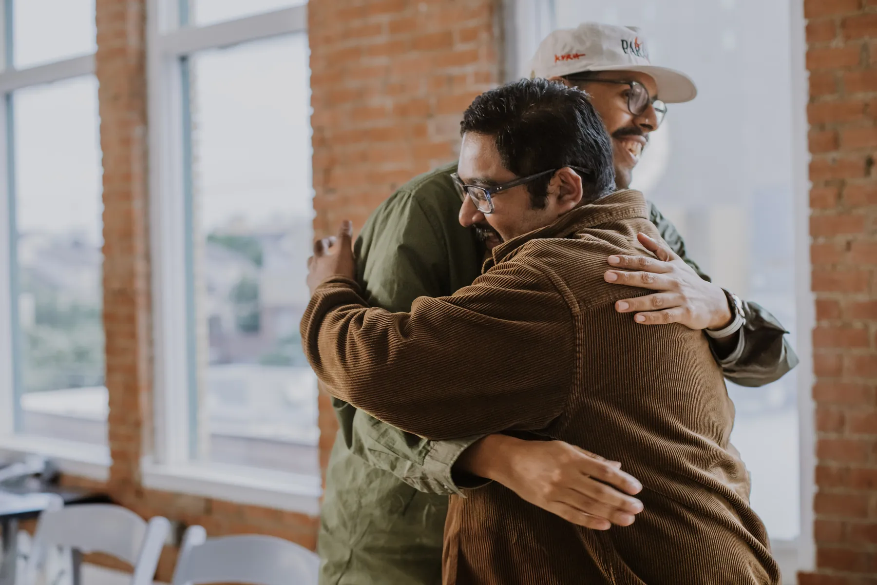 Two men hugging by a window