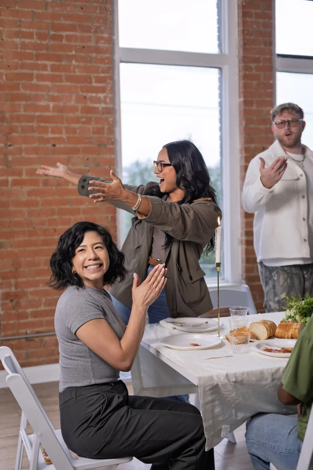 A woman waving hello across the table