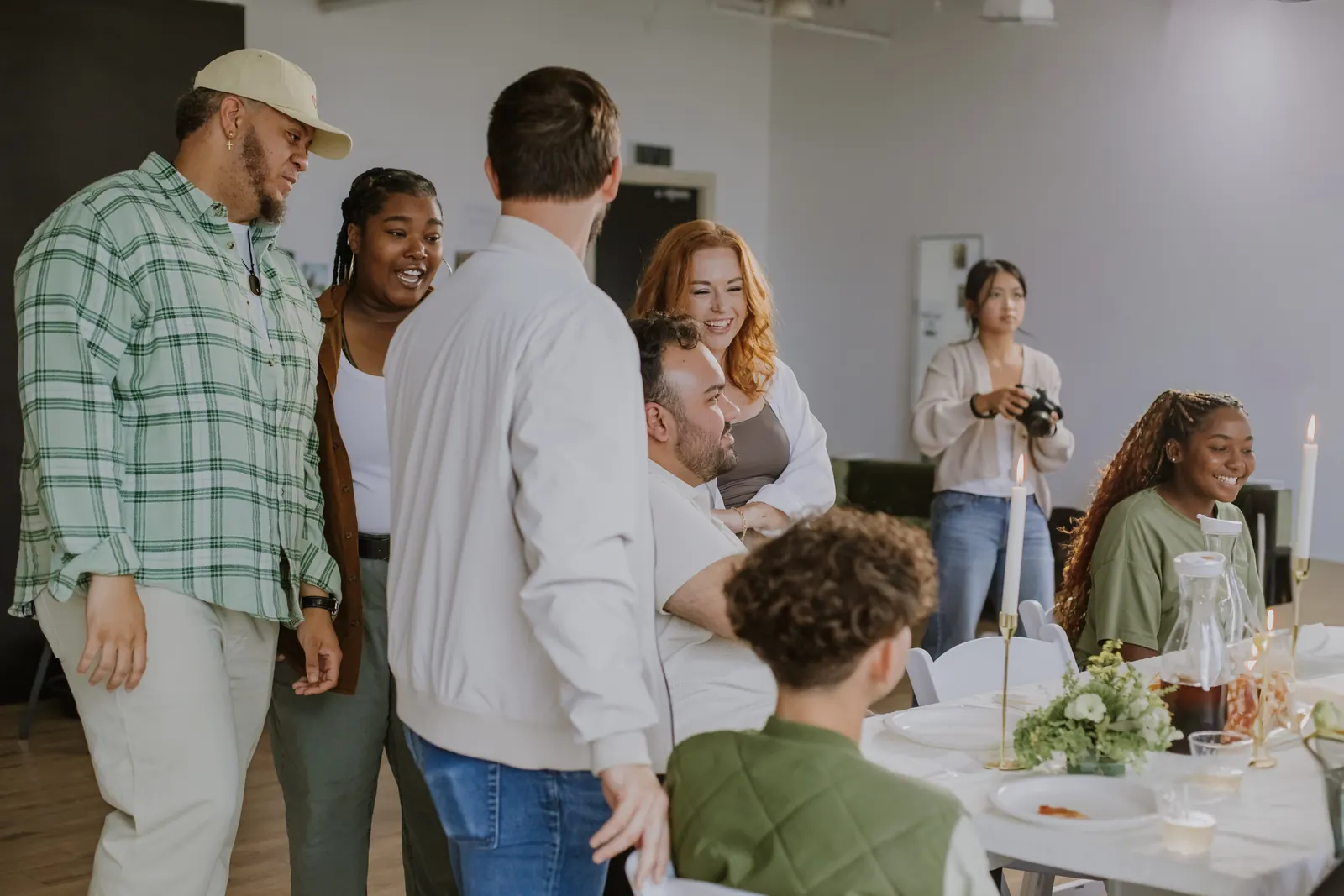 People greeting each other around a set table