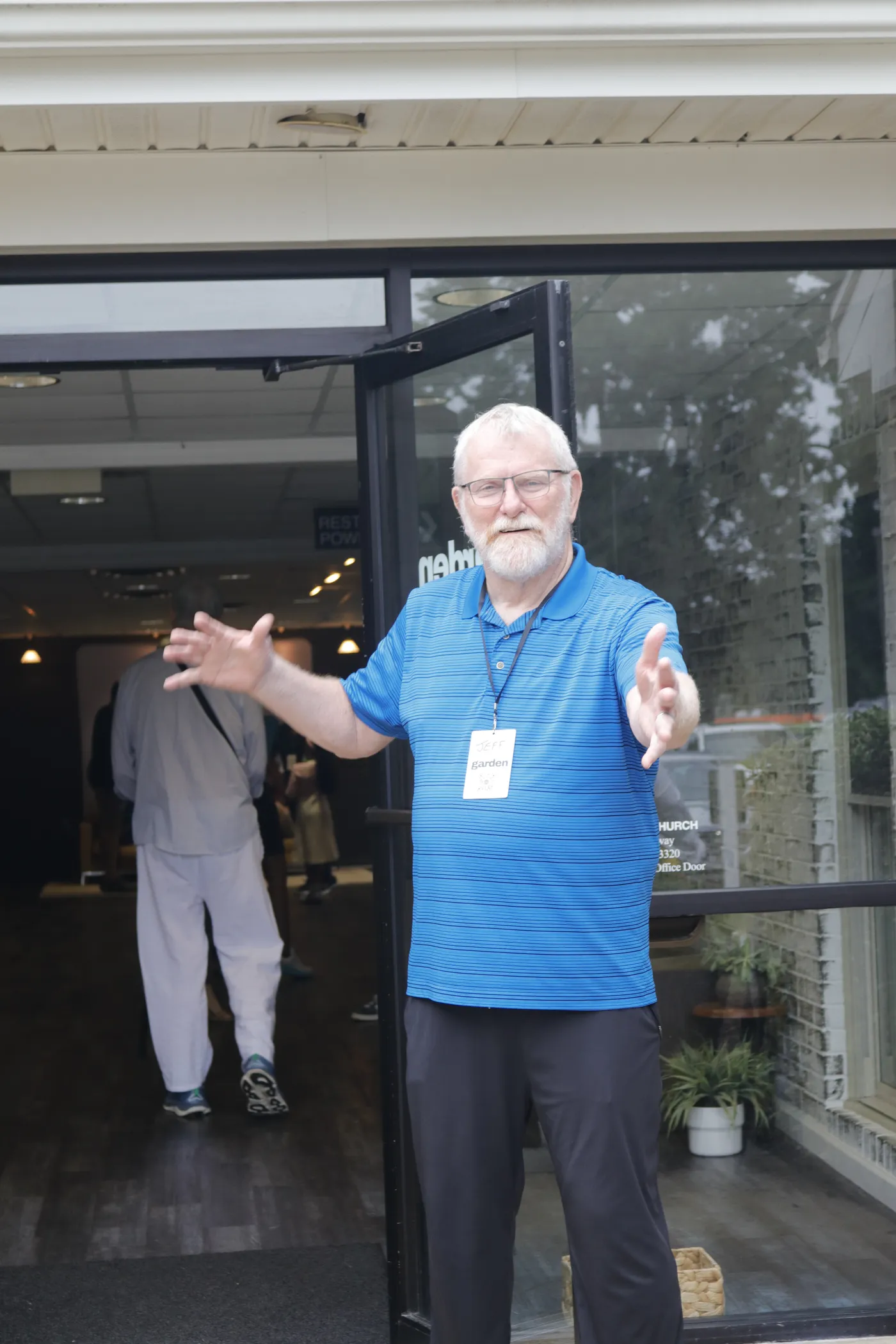 A greeter at the front door, arms open