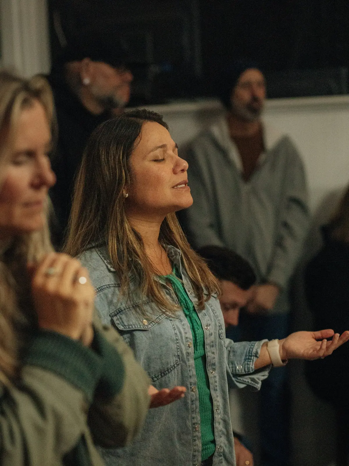 Two women worshipping, eyes closed