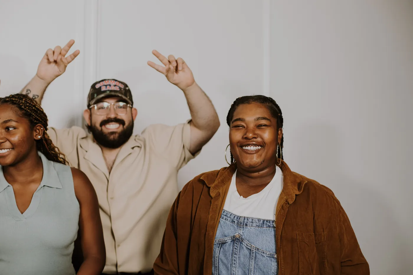 Three friends laughing with their hands up at a Garden Co. gathering