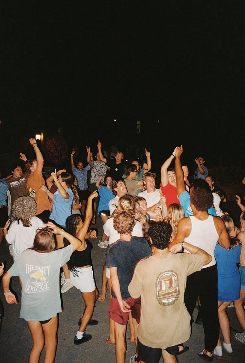 A crowd of students dancing outside at night